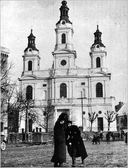 Two Jews standing near a church in the marketplace in Czestochowa.